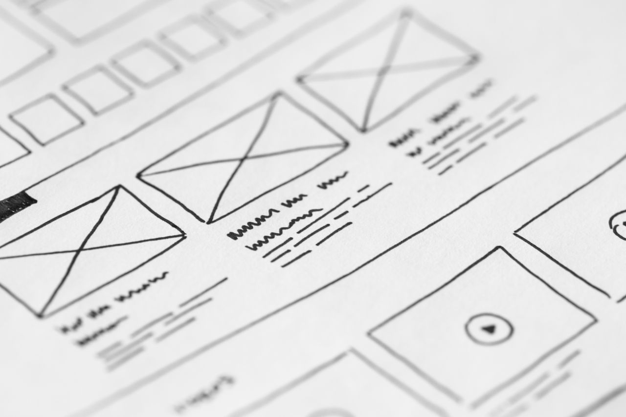 hero-img-02 Gros plan détaillé d’un wireframe dessiné à la main sur papier pour un projet UX.